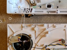 Internal turntable view showing tonearm wires connected to RCA plugs