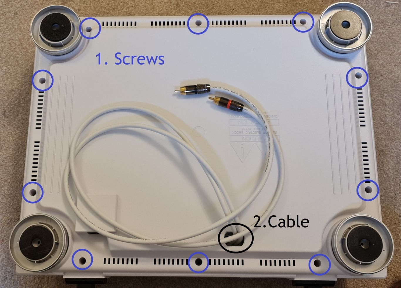 Bottom view of a PLX 500 turntable, highlighting screw and cable holes