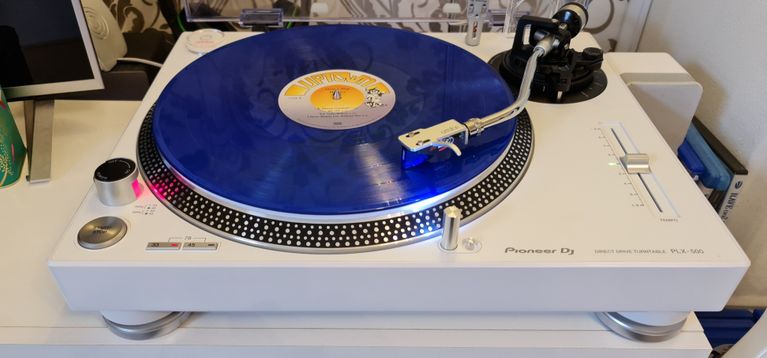 White Pioneer PLX 500 DJ turntable, playing a blue record