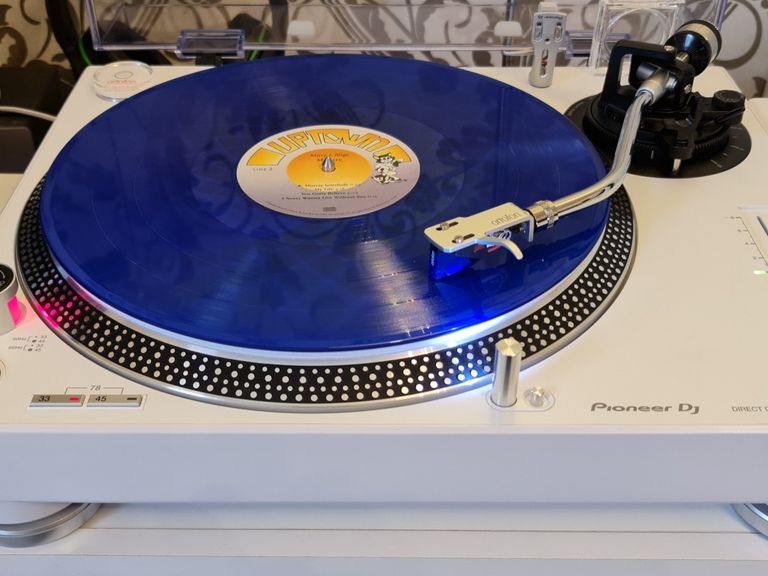 White Pioneer PLX 500 DJ turntable, playing a blue record